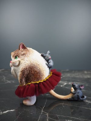 Fat cat playing w/ 2 gray mouse in red fabskirt