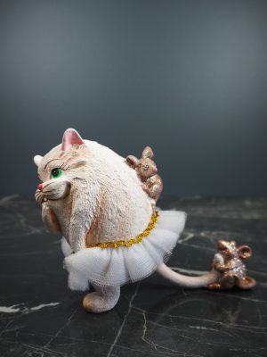 Fat cat playing w/ 2 dark brwn mouse in whte fabskirt