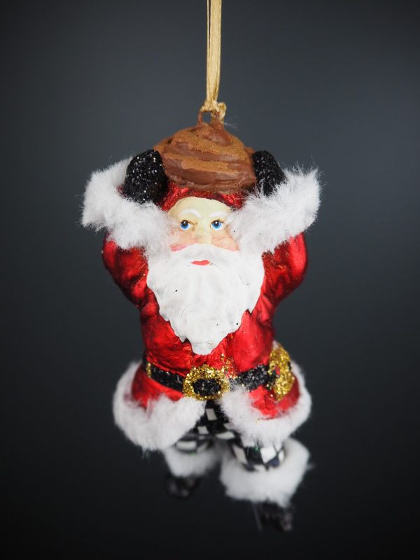 Santa holding kanelbulle in satin red coat & checkered pants